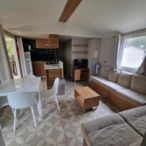 a living room with a couch and a table at Mobilhome Piriac Sur Mer in Piriac-sur-Mer