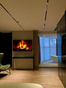 a living room with a fireplace and a bath tub at BAZ'HUR Boutique Hotel in Kukës