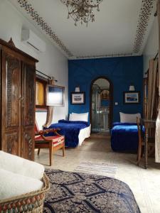 1 dormitorio con 2 camas y pared azul en RIAD Dar Ouezzani en Rabat