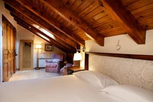 um quarto com uma cama, um sofá e uma cadeira em Pleta Ordino 51, Duplex rustico con chimenea, Ordino, zona Vallnord em Ordino