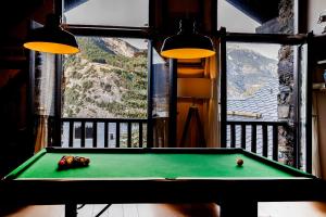 uma mesa de bilhar num quarto com vista para uma montanha em Pleta Ordino 51, Duplex rustico con chimenea, Ordino, zona Vallnord em Ordino