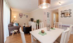 a dining room and living room with a white table and chairs at Los Rosales Apartamento in Cala Millor