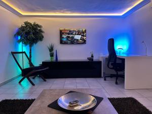 - un salon avec éclairage bleu, table et chaises dans l'établissement Modernes Apartment mit Terrasse und Highspeed Internet zwischen Aalen und Schwäbisch Gmünd, à Göggingen