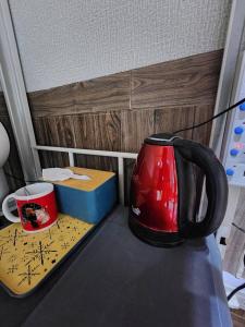 a red tea kettle and a box on a counter at 113 Olan Place Cozy Loft Apartment with free Wi-fi in Bangkok