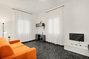 a living room with an orange couch and a television at Dal pozzo appartamento in Deiva Marina