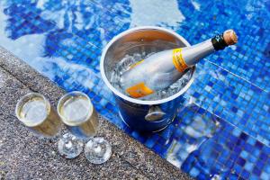 eine Flasche Champagner in einem Eimer neben zwei Gläsern in der Unterkunft Hotel Villa Caletas in Jacó