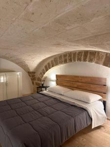 una camera con un grande letto in una parete in pietra di L'Antica Dimora in Centro a Bari