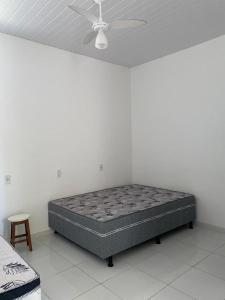 a bed in a room with a ceiling fan at Casa de praia em Ubu- Anchieta -ES in Anchieta
