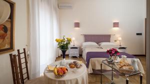 una habitación de hotel con 2 camas y una mesa con fruta en Boutique Villa Magnolia Luxury Suites, en Nardò