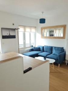 - un salon avec un canapé bleu et une table dans l'établissement Bel appartement 3 suites privatives hyper centre, à Tourcoing