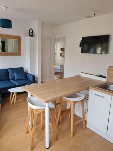 - une table et des chaises en bois dans le salon dans l'établissement Bel appartement 3 suites privatives hyper centre, à Tourcoing