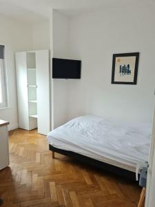 um quarto com uma cama e uma televisão na parede em Bel appartement 3 suites privatives hyper centre em Tourcoing