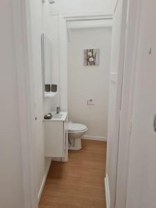 Baño blanco con aseo y lavamanos en Bel appartement 3 suites privatives hyper centre, en Tourcoing