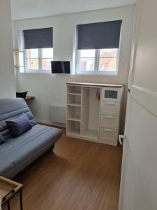 a living room with a couch and two windows at Bel appartement 3 suites privatives hyper centre in Tourcoing