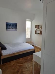 een slaapkamer met een bed en een raam bij Bel appartement 3 suites privatives hyper centre in Tourcoing