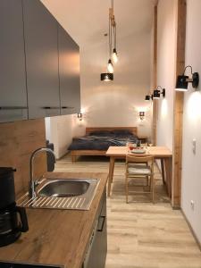 a kitchen with a sink and a table with a bed at Loft - Luxus Apartment zum Wohlfühlen im Allgäu in Marktoberdorf