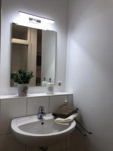 a white bathroom with a sink and a mirror at Loft - Luxus Apartment zum Wohlfühlen im Allgäu in Marktoberdorf
