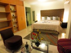 a hotel room with a bed and a chair at Plaza Real Hotel in Encalada