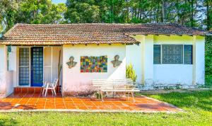 uma pequena casa com um banco à frente em Chácara 2 com Wi-Fi e churrasqueira em Holambra SP em Holambra