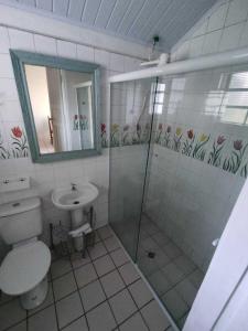 uma casa de banho com um chuveiro, um WC e um lavatório. em Chácara 2 com Wi-Fi e churrasqueira em Holambra SP em Holambra