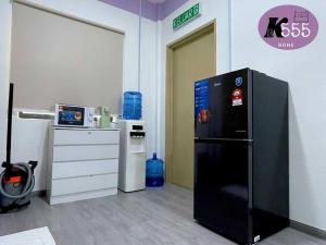 cocina con nevera negra en una habitación en K555 Home Stay, en Kuala Terengganu