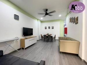 Una sala de estar con un sofá y un televisor de pantalla plana. en K555 Home Stay, en Kuala Terengganu