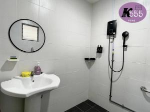 Un baño con lavabo y ducha con espejo. en K555 Home Stay, en Kuala Terengganu