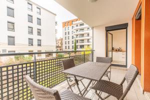 a balcony with a table and chairs with a view at Le 35 Jean-Jaurès F3 avec garage in Clermont-Ferrand
