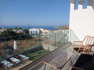 Un balcón con sillas y vistas al océano. en Sapphire Nevelo Quality Villas, en Gerani