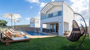 a house with a yard with a swing at Sapphire Nevelo Quality Villas in Gerani