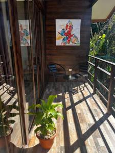 a porch with two chairs and a table and a painting at Casa Colibrí in Tilarán