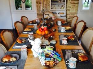 a long wooden table with food on it at Le Petit Domaine de Colayrac in Colayrac-Saint-Cirq