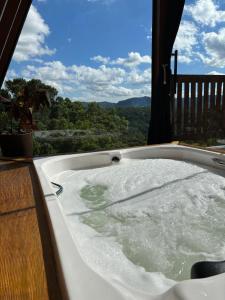 a jacuzzi tub on a deck with a view at Reserva Linha Bonita in Gramado