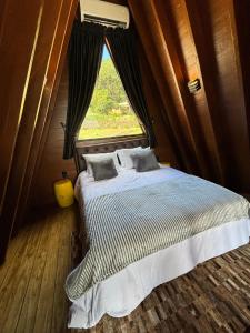 uma cama num quarto com uma janela em Reserva Linha Bonita em Gramado