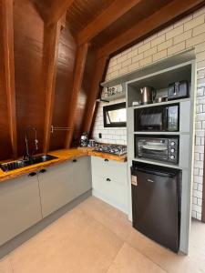 a kitchen with a black refrigerator and a sink at Reserva Linha Bonita in Gramado