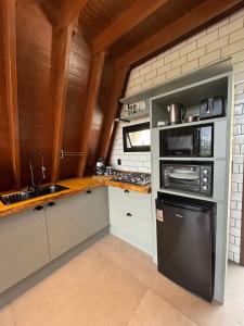 a kitchen with a black refrigerator and a sink at Reserva Linha Bonita - Chalés Românticos in Gramado +47 photos