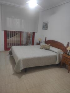 Schlafzimmer mit einem Bett, einem Tisch und einem Fenster in der Unterkunft Apartamento Frente Al Mar in Villajoyosa