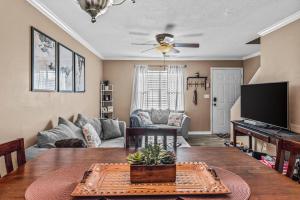 a living room with a table and a tv at Woodstone Retreat Condo right next to UGA golf course! in Athens