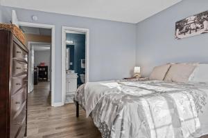 a white bedroom with a bed and a dresser at Woodstone Retreat Condo right next to UGA golf course! in Athens