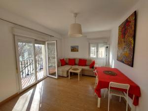 a living room with a red table and a couch at Sirena Center apartment in Seville