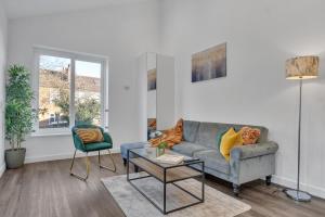 a living room with a couch and a chair at homely North London Apartments Hendon in The Hyde