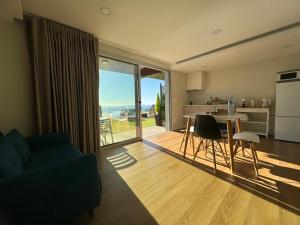 Una sala de estar con cocina y una mesa con sillas. en Madeira Sea Sunshine with heated pool, en Ribeira Brava