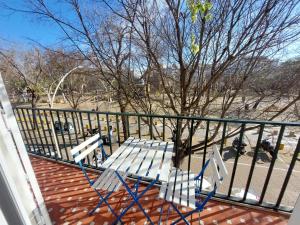 a white bench on a porch with a fence at Sirena Center apartment in Seville