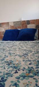 a bedroom with a bed with blue pillows at Casa Blanca 