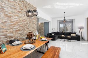a living room with a table and a brick wall at Villa Livis 1 in Kiotari