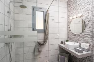 a white bathroom with a sink and a mirror at Villa Livis 1 in Kiotari +27 photos