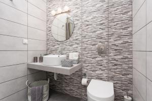 a bathroom with a sink and a toilet and a mirror at Villa Livis 1 in Kiotari +16 photos