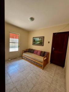a bedroom with a couch in a room with a window at Casa Aconchegante em Teresópolis in Teresópolis
