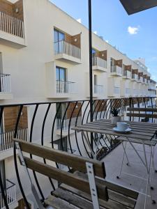 un balcón con mesa y sillas y un edificio en KORZO SUITES SLIEMA III, en Sliema