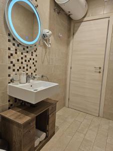 a bathroom with a sink and a mirror and a shower at KORZO SUITES SLIEMA III in Sliema